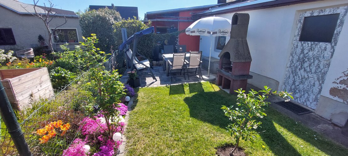 Terrasse einer Ferienwohnung mit Tisch und Stühlen